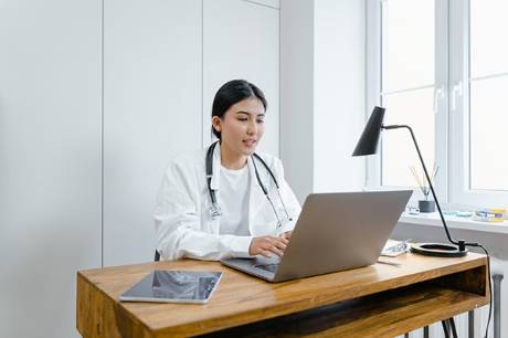 A doctor working on a laptop